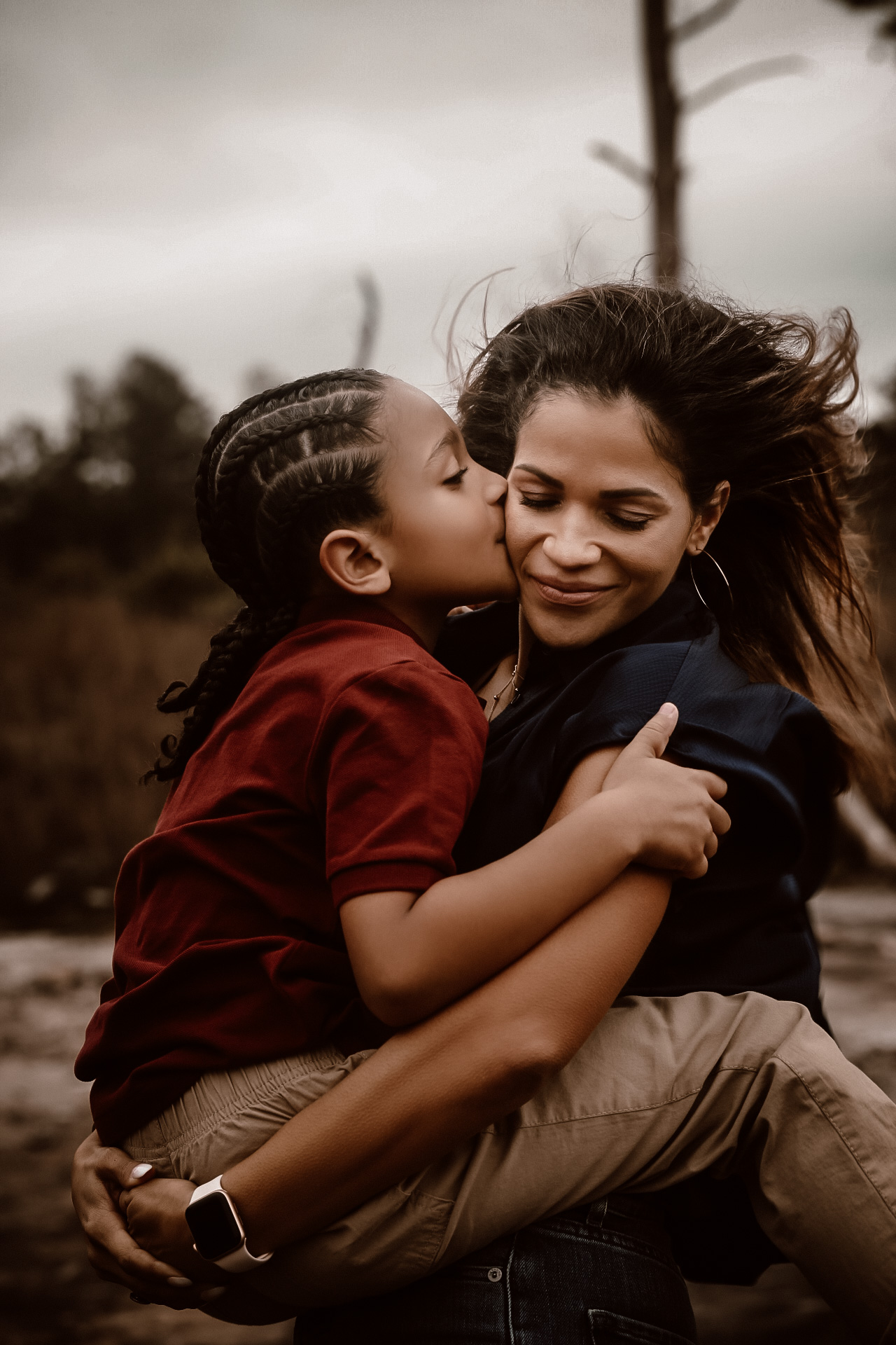 Mom holding her don while he is kissing her on the cheek with their eyes closed - Fall Family photography - - Arabia Mountain Portrait Photography