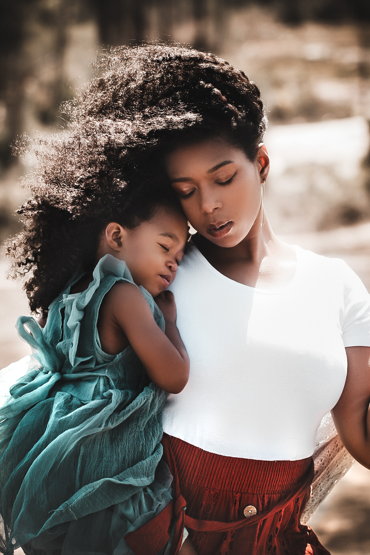 Mom and daughter on top of arabia mountain while hugging with their eyes closed - Hair blowing in the wind Fall Family photography - - Arabia Mountain Georgia Portrait Photography