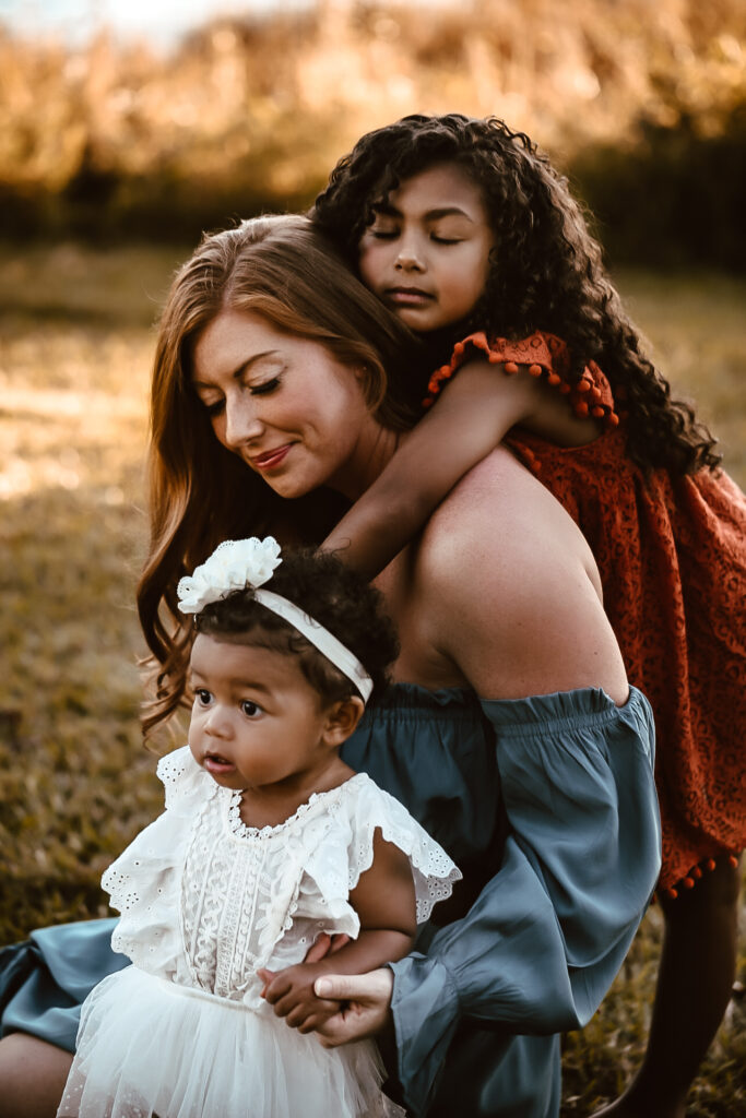 Mom and her 2 daughters all hugging each other with ryes closed - Acworth Beach family portrait- Motherhood