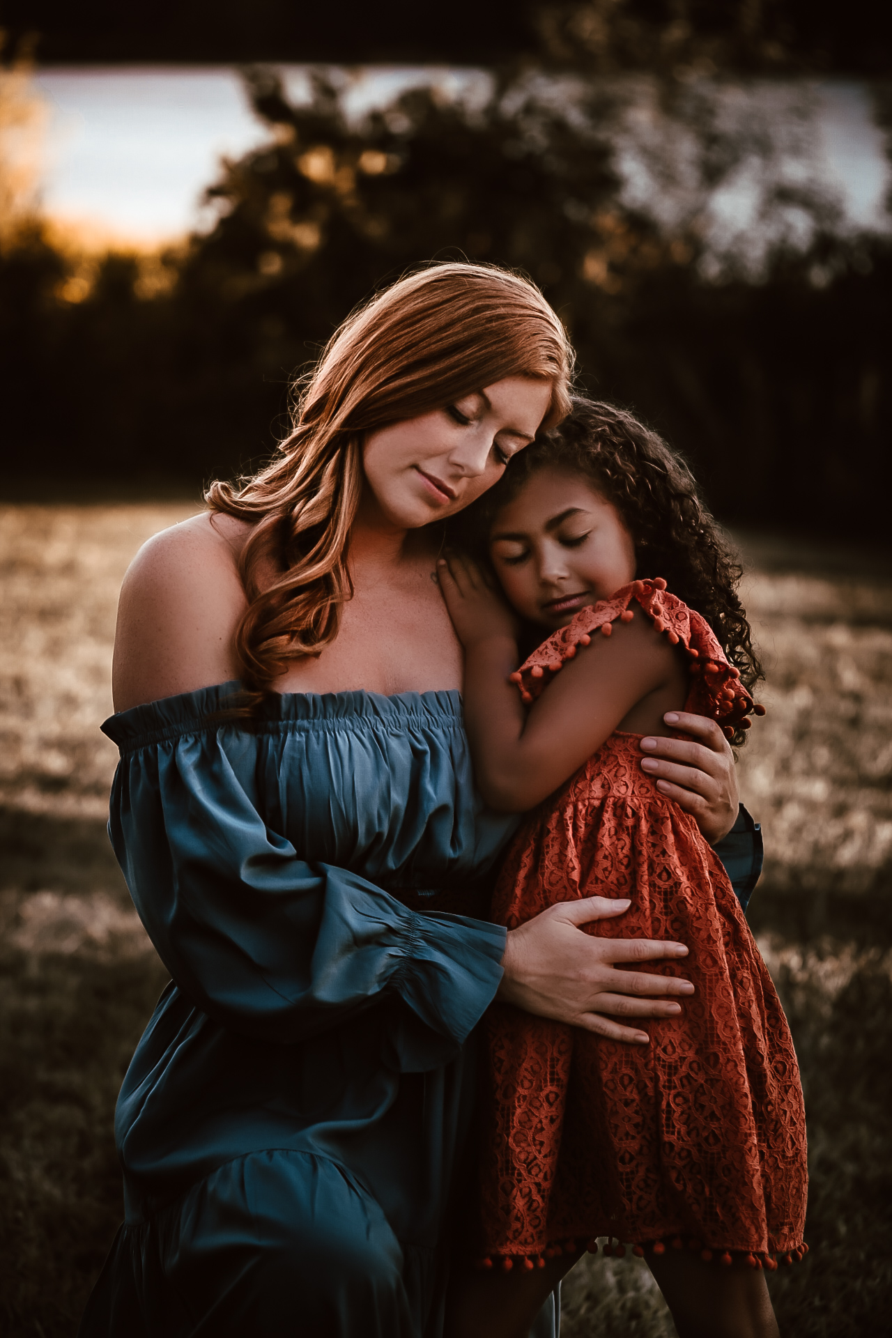 Mom and daughter kneeling on the ground while hugging and eyes closed Motherhood-Family photography Acworth Beach Georgia Photography