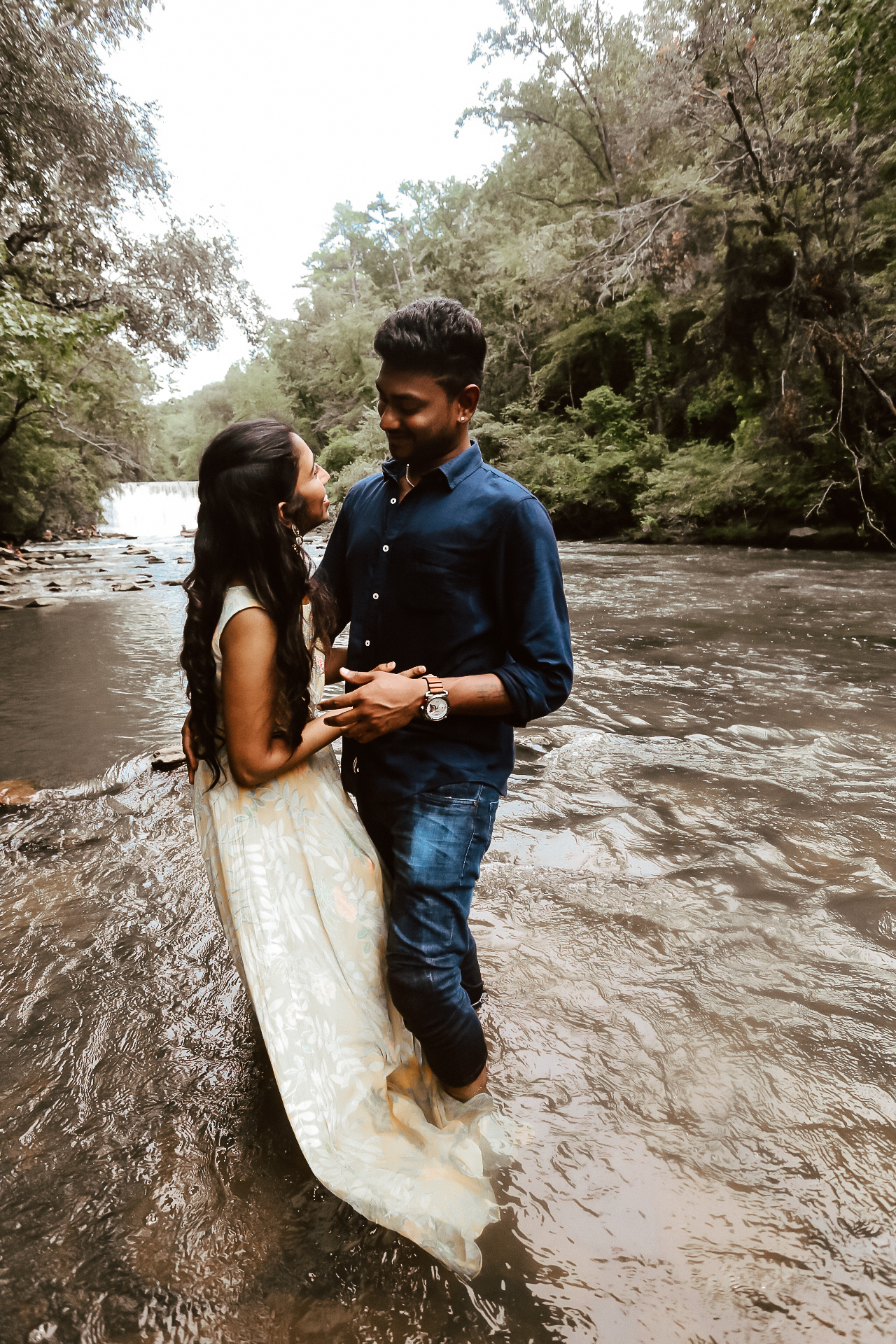 Husband and wife standing insideof th river while embracing each other and smiling - Roswell Mill Indian Family photography