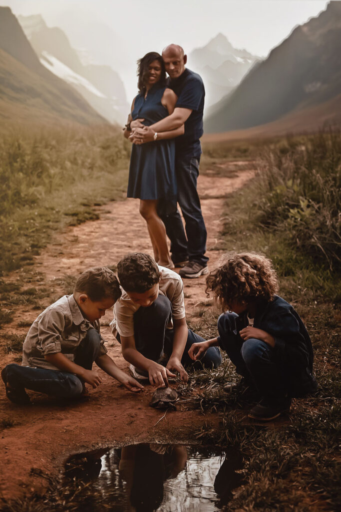 Three brother on the ground playing with a turtle with mom and dad in the background. Fall Family photography - - Green Meadow Preserve Family photo Link to the full gallery of this session