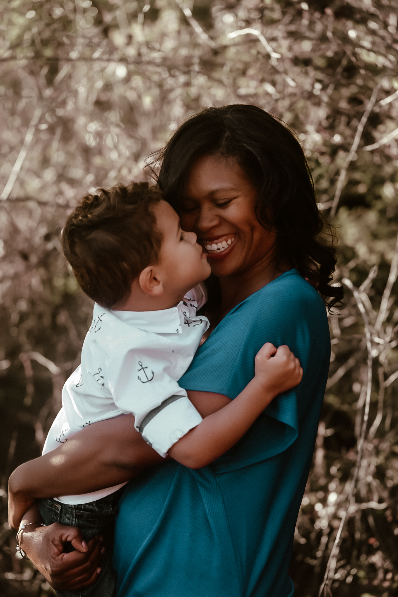 Mom holding her young son while both looking at each other and laughing. Fall Family photography - - Arabia Mountain Portrait Photography