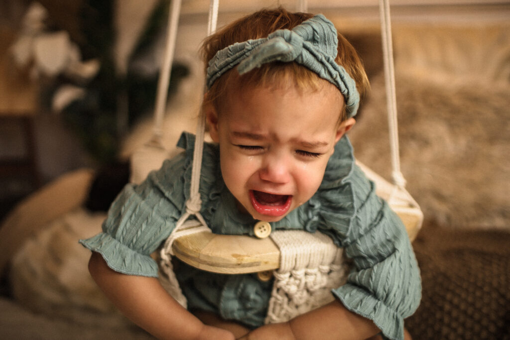 Baby crying in baby swing because she wants to play