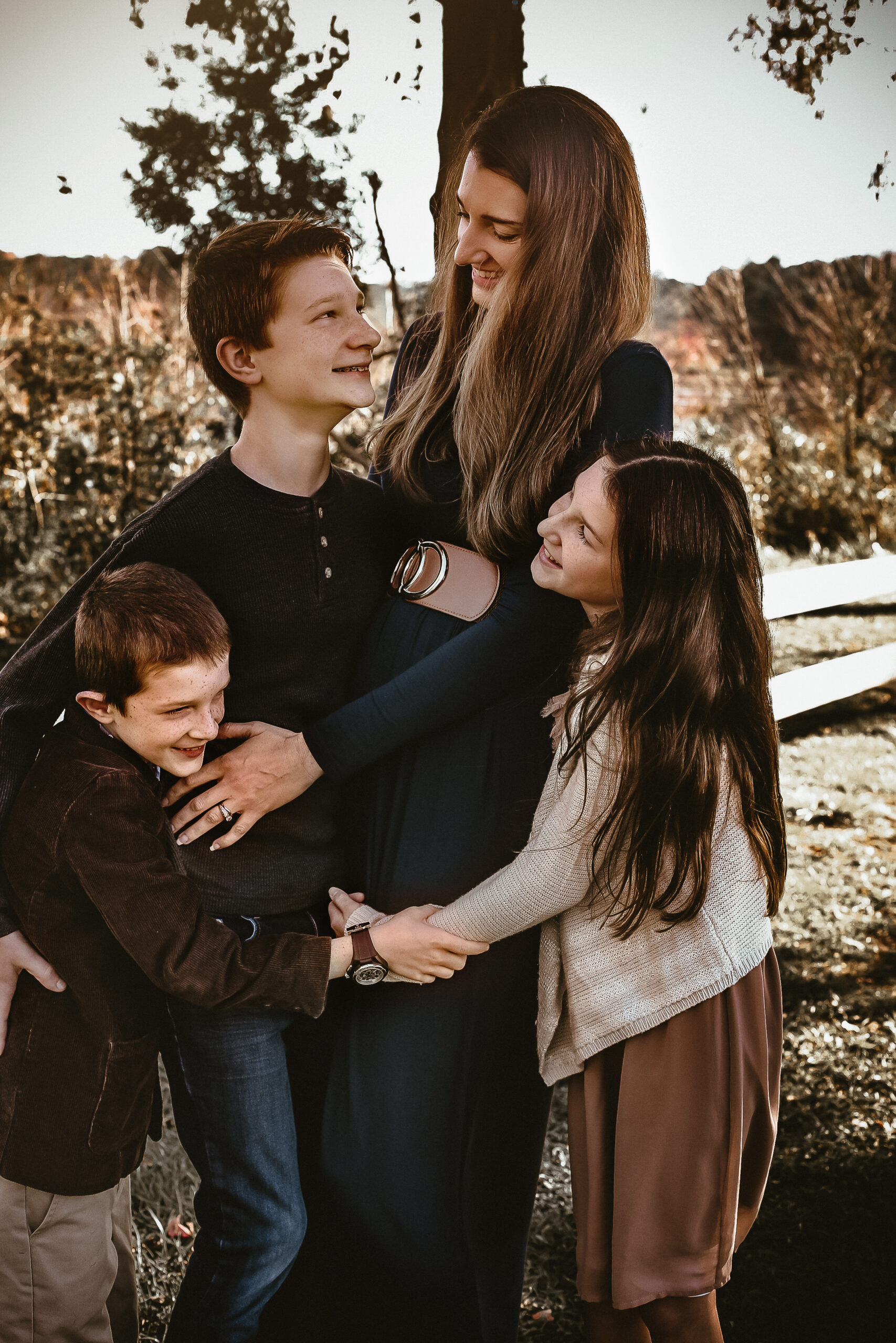 Family of four hugging eachother and smiling at each other