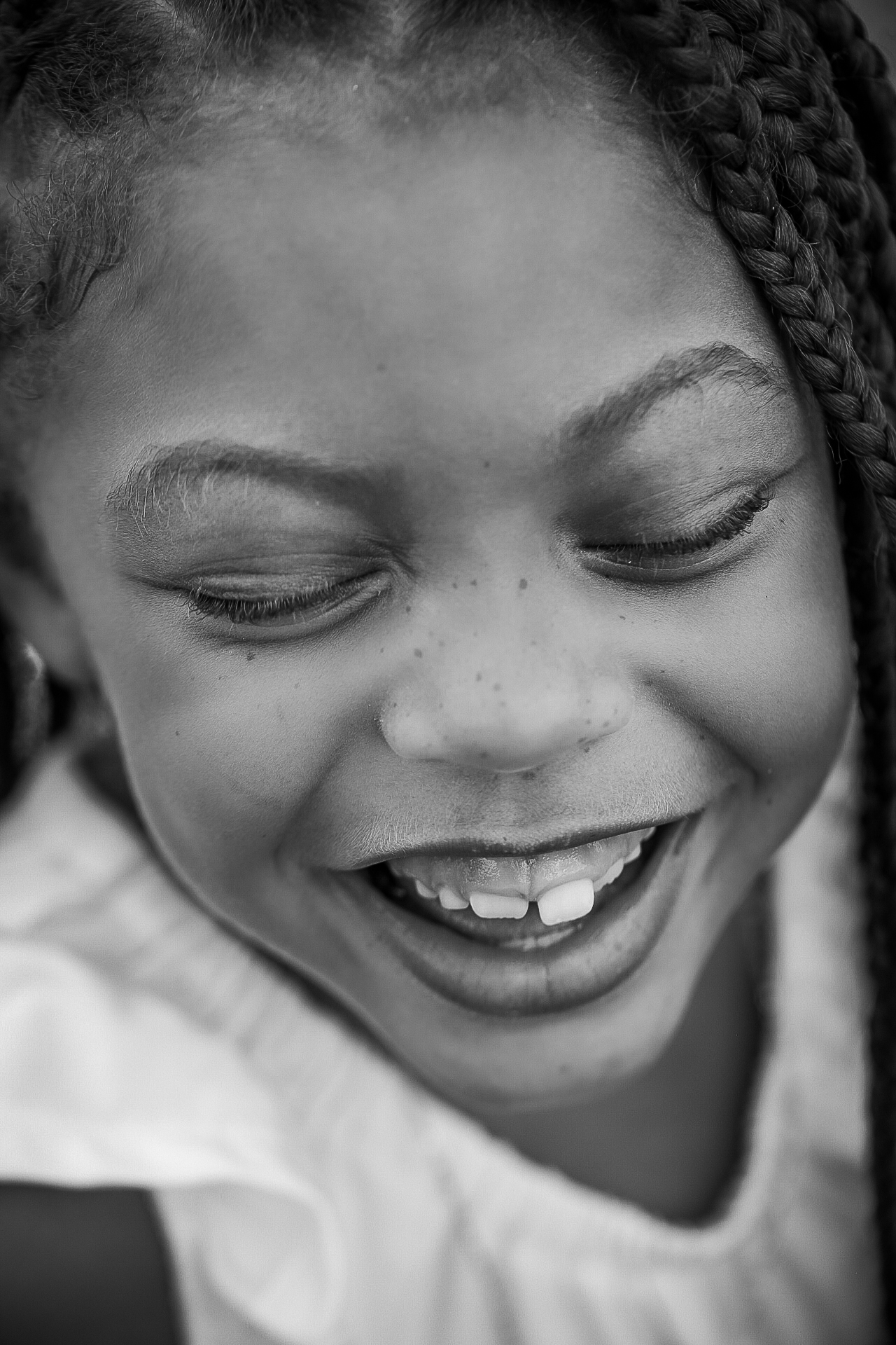 Black and white portrait of a young girl laughing over her shoulder