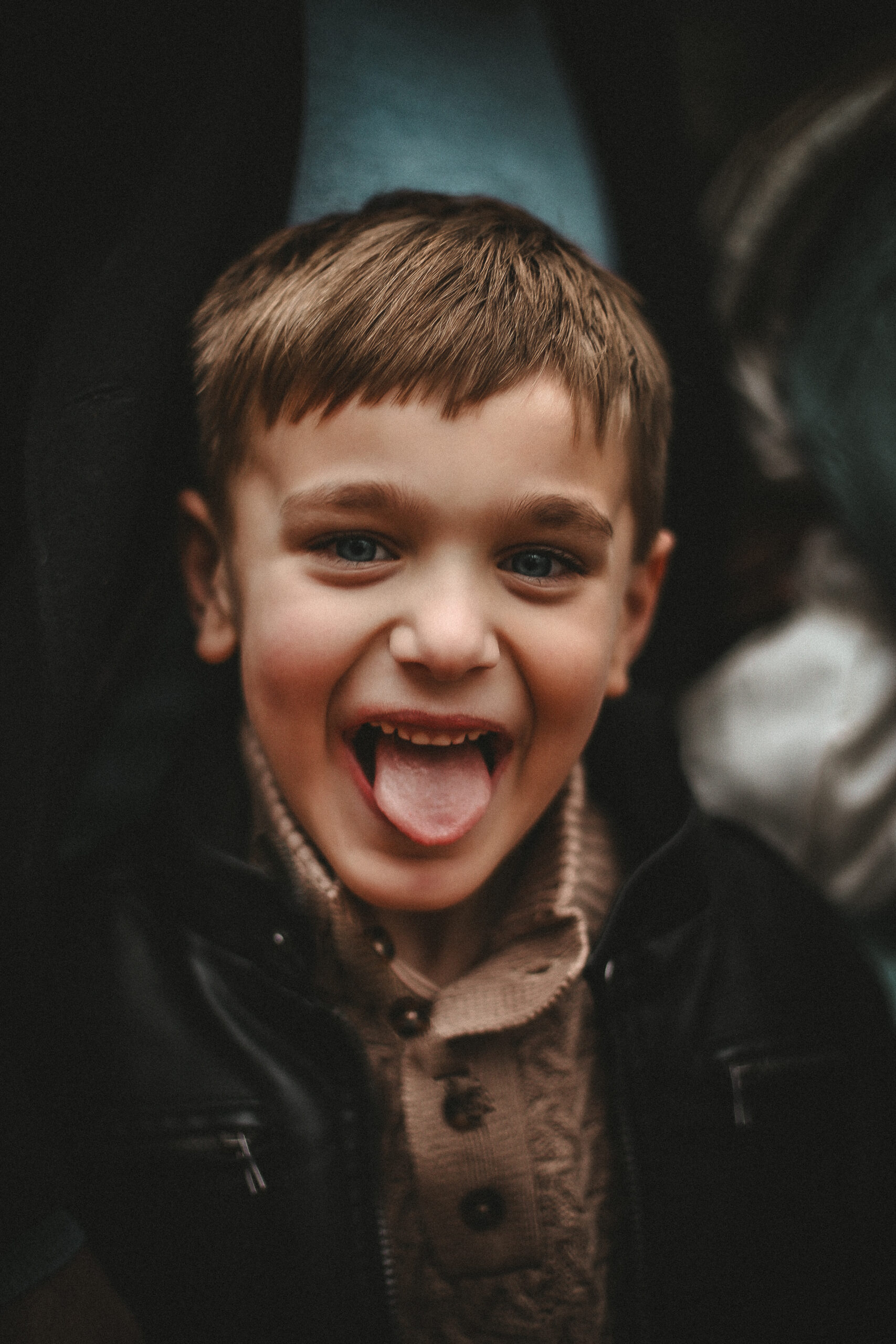 Close up of young boy laughing and smiling a the camera with his tongue out